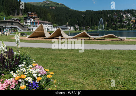 Arosa, GR / Switzerland - 24. July, 2019: the lakeshore in Arosa with the train and cable railway station in the background Stock Photo