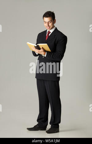 Businessman reading a book and smiling Stock Photo