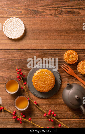 Creative Moon cake Mooncake table design - Chinese traditional pastry with tea cups on wooden background, Mid-Autumn Festival concept, top view, flat Stock Photo