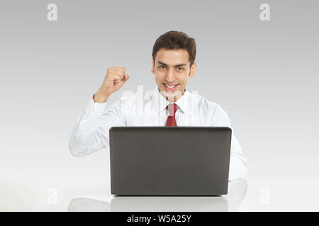 Businessman working on a laptop and smiling Stock Photo