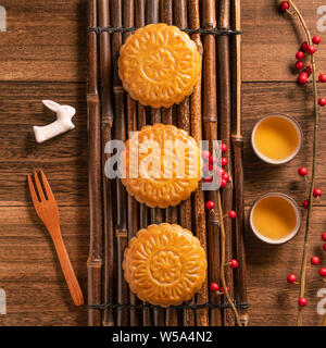 Creative Moon cake Mooncake table design - Chinese traditional pastry with tea cups on wooden background, Mid-Autumn Festival concept, top view, flat Stock Photo