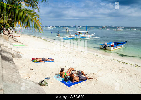 Young People Sunbathing On Alona Beach, Bohol, The Philippines Stock Photo