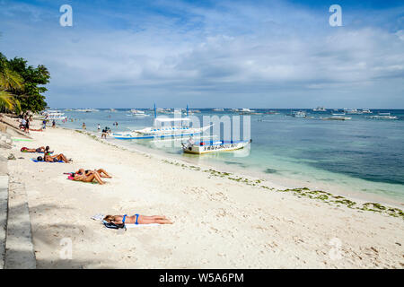 Young People Sunbathing On Alona Beach, Bohol, The Philippines Stock Photo