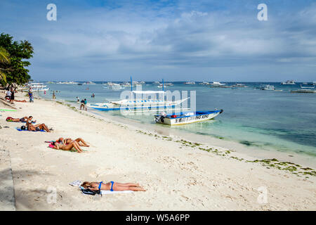 Young People Sunbathing On Alona Beach, Bohol, The Philippines Stock Photo