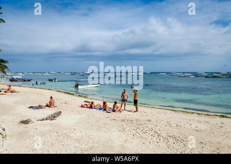 Young People Sunbathing On Alona Beach, Bohol, The Philippines Stock Photo
