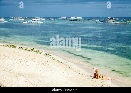 Young People Sunbathing On Alona Beach, Bohol, The Philippines Stock Photo