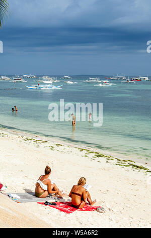 Young People Sunbathing On Alona Beach, Bohol, The Philippines Stock Photo