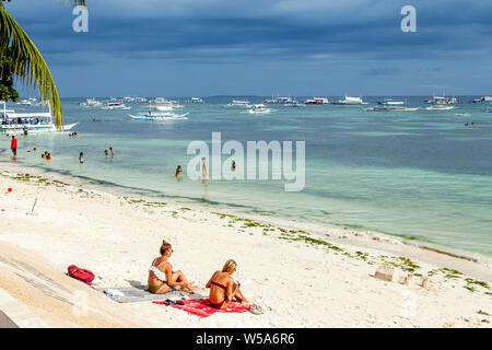 Young People Sunbathing On Alona Beach, Bohol, The Philippines Stock Photo