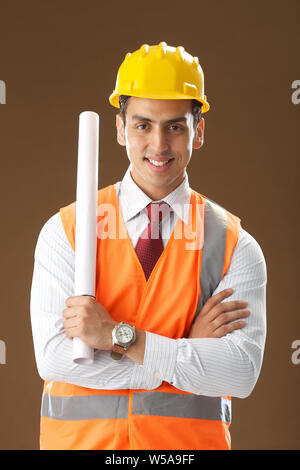 Male architect holding a blueprint and smiling Stock Photo