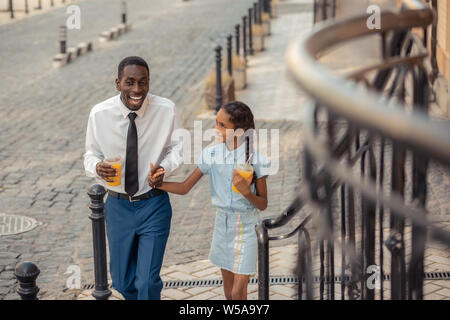 Emotional dark-skinned male person telling funny story Stock Photo