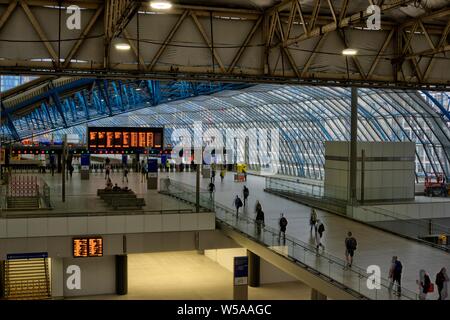 London, United Kingdom - July 22, 2019: Waterloo train station on weekday morning showing motion blurred commuters on new concourse