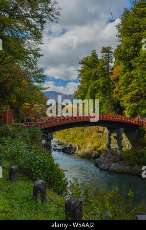 Famous Shinkyo Bridge in Nikko leading over the river Daiyo-gawa, painted in vermilion red and captured during autumn, Japan October 2018 Stock Photo