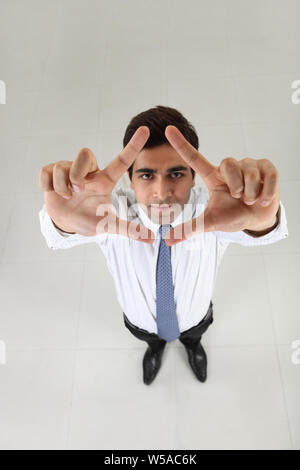 Businessman framing face with fingers Stock Photo