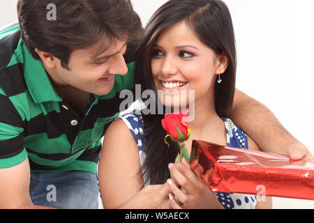 Man giving a gift to his wife and smiling Stock Photo