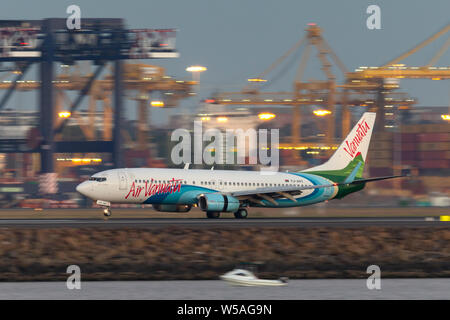 Air Vanuatu Boeing 737 airliner landing at Sydney Airport after sunset. Stock Photo