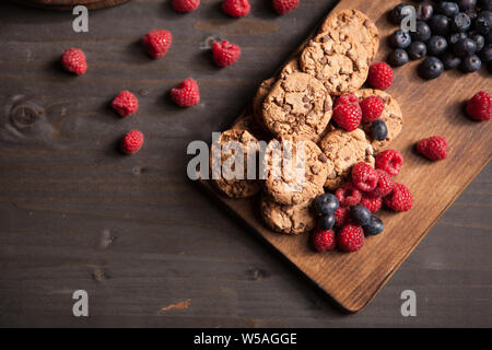 Top view of tasty homemade dessert with milk and blueberries on wooden board. Chocolate chips. Stock Photo