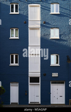 London, UK - July, 2019. Façade of a blue painted masonry residential building with white door and windows in Clink Street, near London Bridge. Stock Photo