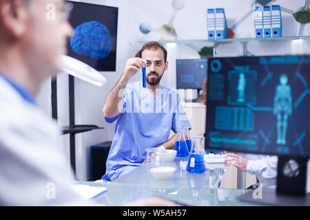 Young scientist engineer working with test tubs in a laboratory. Scientist doing experiments for pharmaceutical development. Stock Photo