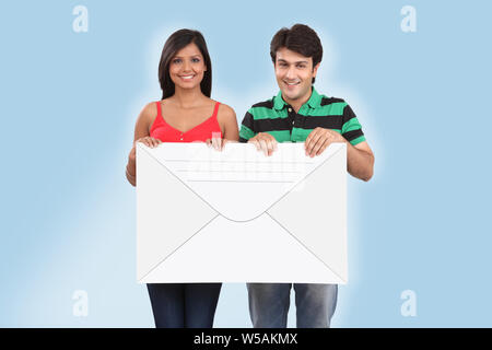 Couple holding an envelope and smiling Stock Photo
