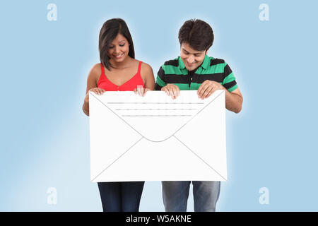 Couple holding an envelope and smiling Stock Photo