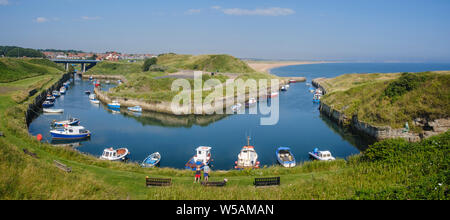 Boats moored in the harbour of the small coastal fishing village of Seaton Sluice in Northumberland Stock Photo