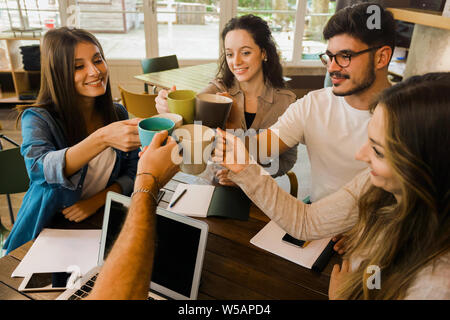 Group of friends studying together and making a toast with coffee Stock Photo