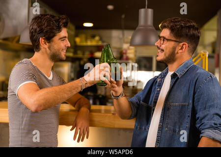 Two friends having a drink at the pub and making a toast Stock Photo