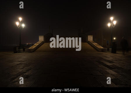 Bridge in Venice at night, one person's shadow rushes through the scene. Stock Photo