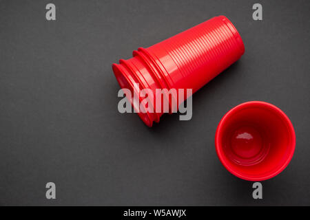 Red plastic glasses on black background, top view Stock Photo