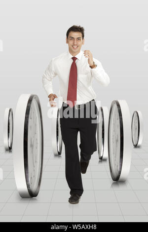 Businessman running with clocks Stock Photo