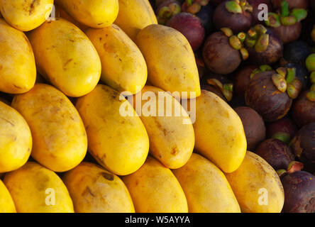 Mango fruits and mangosteens lay on a counter. Marketplace of Kota Kinabalu, Malaysia Stock Photo