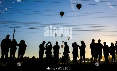 Araçoiaba da Serra, São Paulo, Brazil. 27th July, 2019.  Twenty balloons take part in the Brazilian Balloon Championship takes place in Araçoiaba da Serra, in the interior of SP, this Saturday morning. Pictured silhouettes of people watching the balloons. (Photo: Cadu Rolim/Fotoarena) Credit: Foto Arena LTDA/Alamy Live News Stock Photo