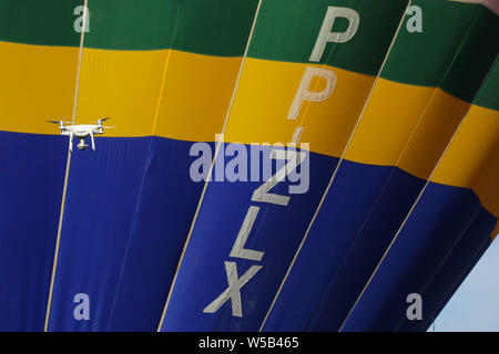 Araçoiaba da Serra, São Paulo, Brazil. 27th July, 2019.  Twenty balloons take part in the Brazilian Balloon Championship takes place in Araçoiaba da Serra, in the interior of SP, this Saturday morning. Drone passes near balloon. (Photo: Cadu Rolim/Fotoarena) Credit: Foto Arena LTDA/Alamy Live News Stock Photo