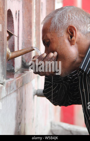 Old Man drinking water from tap Stock Photo