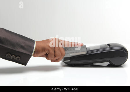 Shop assistant swiping credit card through machine Stock Photo