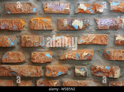 Photo background wall of brown old decorative brick with scratches, scuffs, cracks. Stock Photo