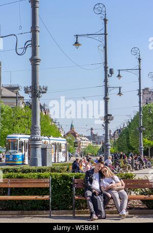 Debrecen Hungary 04 19 2019 young couple sitting on a bench in Debrecen Kossuth Square Stock Photo