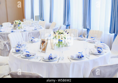 Wedding table setting in the restaurant on the white and blue background. Stock Photo