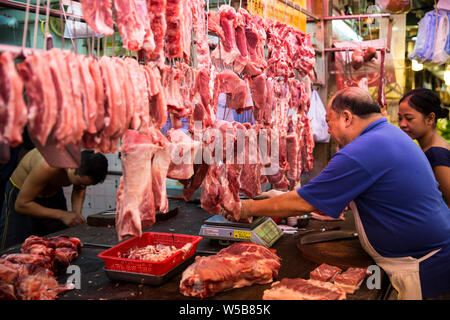 Butcher weighing meat at Fa Yuen market. Hong Kong Stock Photo