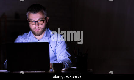 Businessman is working on laptop in darkness Stock Photo