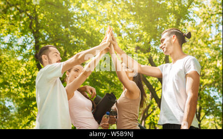 Excited young people giving high five after successful training together Stock Photo