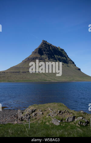 Mt. Kirkjufell in May - A crisp and clear sky enhances the beauty of this mountain. Stock Photo