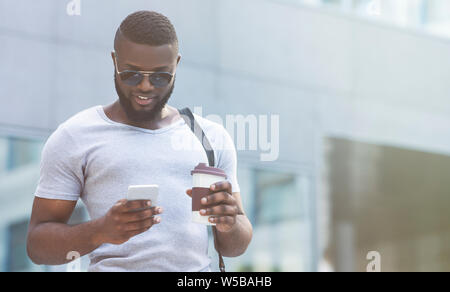 Handsome african man in sun glasses using social networks Stock Photo