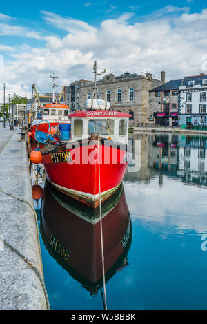 Little red fishing boat at Sutton Harbour, formerly known as Sutton Pool, original port of City of Plymouth at historic Barbican district. Devon. UK. Stock Photo