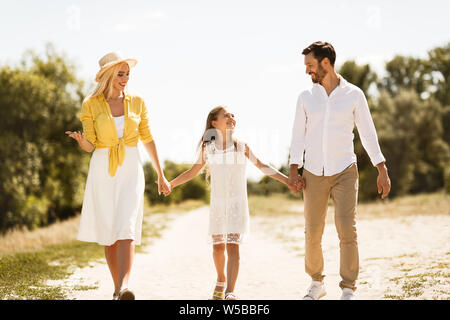 Happy family walking on path holding hands Stock Photo