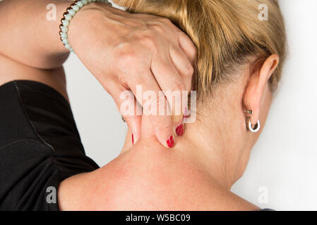 Mature women with neck pain. Self massage concept Stock Photo