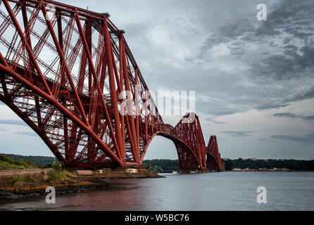 The world famous Forth Rail Bridge at sunset in Edinburgh, Scotland. Repairing works are taking place on the bridge Stock Photo