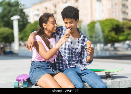 Happy couple eating ice cream in the street Stock Photo