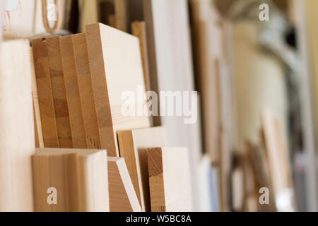 A wooden pillars and thick boards in the furniture workshop are ready to work joiner, selective focus Stock Photo