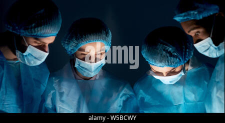 Team of surgeons performing operation in hospital Stock Photo